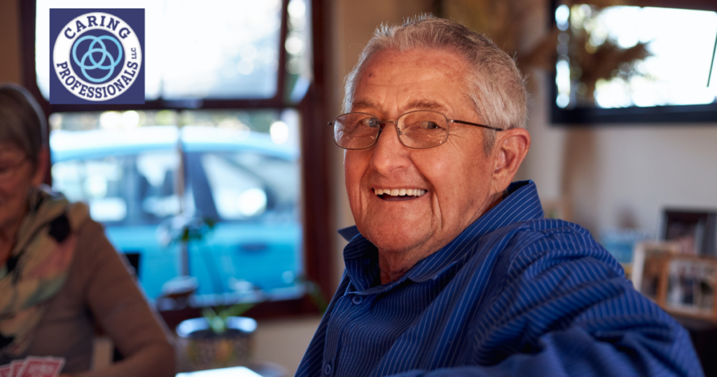 A senior man is sitting in his own home, happy, as a result of successful long-distance caregiving.