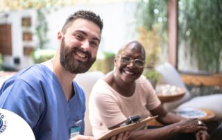 A man enjoys his caregiver job as he works with a client.