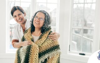 A caregiver hugs an older client representing the kind of good environment a caregiver has the potential to create with new clients.