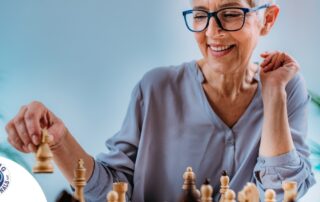 An older woman plays chess, an activity that can help older adults stay sharp.