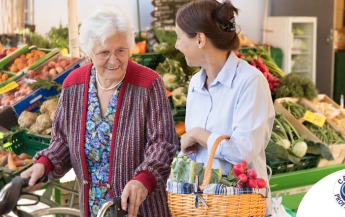 A caregiver shops for groceries with an older adult, representing shopping for a diabetes-friendly diet.