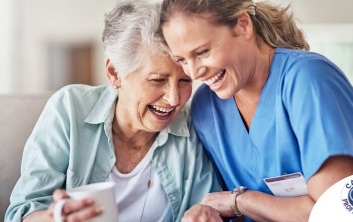 A caregiver laughs with a client representing how good social skills can help professional caregivers.