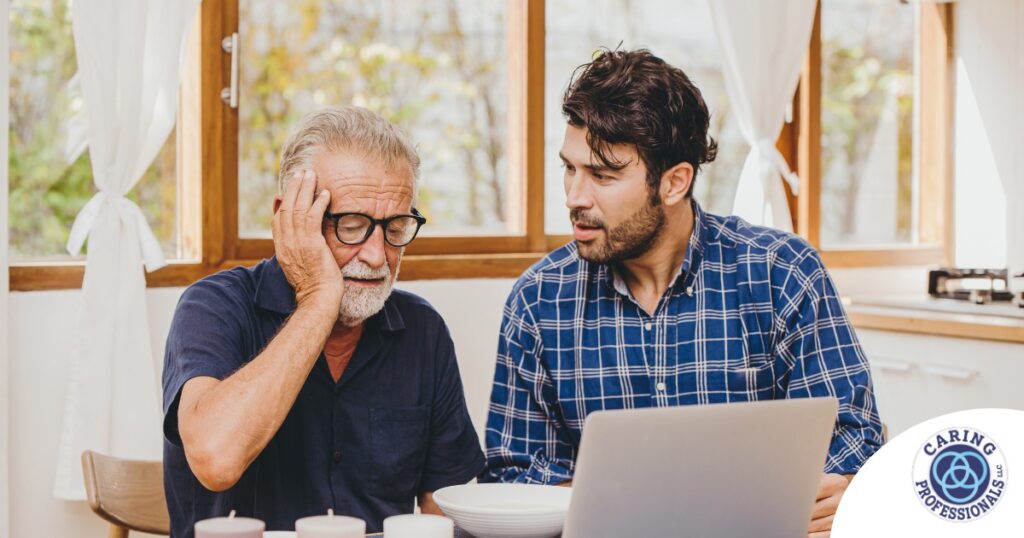 A man looks at a computer with his father who is confused, representing one of the early signs of dementia.